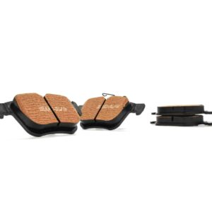 Two brown textured bicycle pedal surfaces with black frames on a white background; shows pedals with traction pads and no visible toe cages.