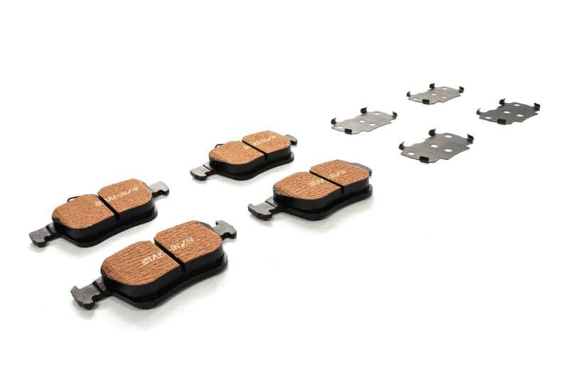 Set of copper-colored disc brake pads with metal shims laid out on a white background, for a bike or vehicle braking system.