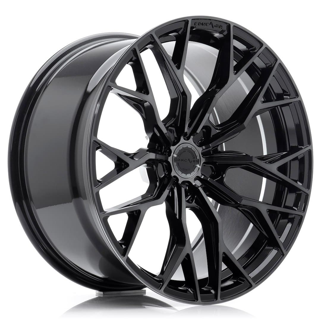 53686_0_39359jpg - OPSHOLDERS Glossy black multi-spoke alloy wheel with a silver inner lip and a central hubcap design.