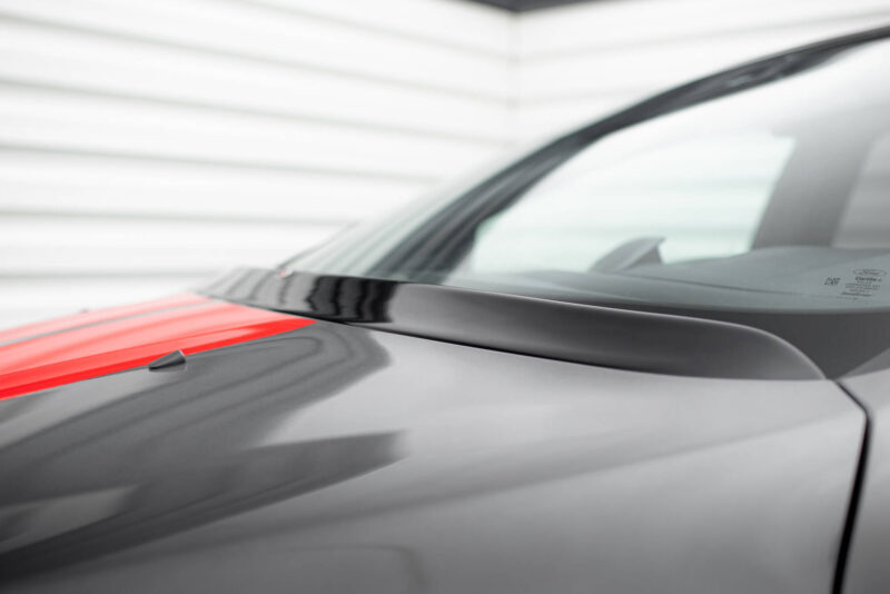 Close-up of a grey car hood with a red stripe and windshield in the background.