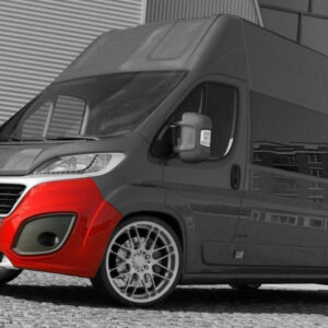 Black and gray delivery van with a bright red front bumper parked on a cobblestone surface, reflecting a nearby building in the side panels.