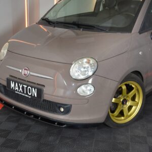 Gray Fiat car on display with gold wheels in a showroom; front license plate reads MAXTON.