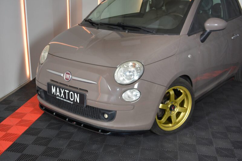 Gray Fiat car on display with gold wheels in a showroom; front license plate reads MAXTON.