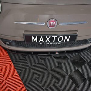 Front view of a beige Fiat car showing the badge and a MAXTON license plate on a red-and-black checkered floor.