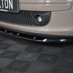 Front of a beige car showing a fog light, honeycomb grille, and a license plate reading 'MAXTON Auto Spa Bochnia.pl' on a checkered floor.