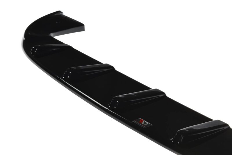 Close-up of a glossy black car spoiler with a small red-and-white badge visible along the edge.