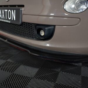 Front end of a brown car with a Maxton license plate, hexagonal grille, round headlight, and fog light on a checkered floor.