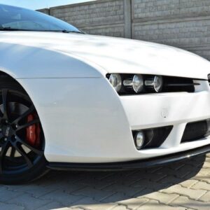 Front-left view of a white sports car with black alloy wheels and red brake calipers on a paved driveway.