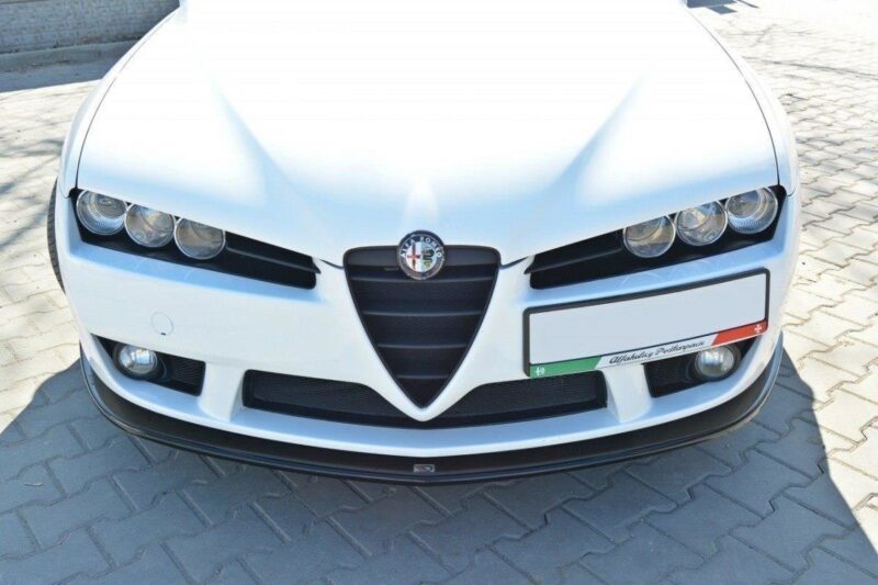 Front view of a white Alfa Romeo car featuring the distinctive V-shaped grille and round headlights with the brand badge centered on the hood, parked on a paved surface.