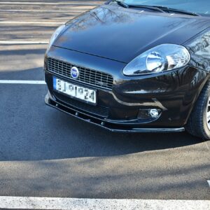 Front-right view of a glossy black Fiat car parked in a parking lot, with white lines visible on the asphalt.
