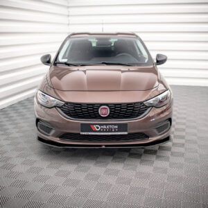 Front view of a brown Fiat SUV in a bright showroom with a checkered floor and white paneled walls, close to the camera showing the grille and emblem