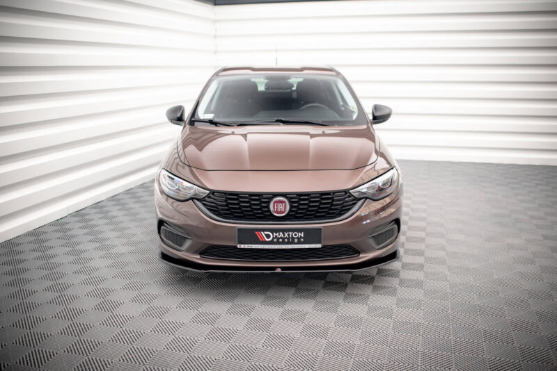 Front view of a brown Fiat car parked indoors against white striped walls in a showroom.