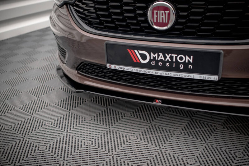 Close-up of a Fiat car front with a black Maxton design plate, chrome badge, and honeycomb grille visible.