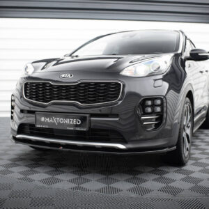 Front three-quarter view of a black Kia SUV in a showroom, highlighting the large grille and headlight cluster in a glossy finish.