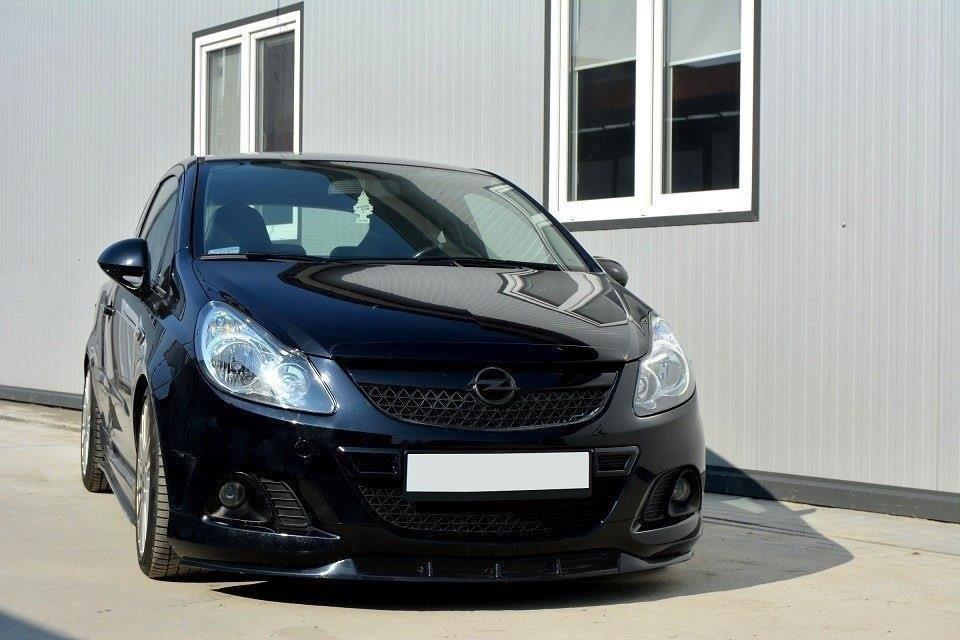 pol_po_FRONT-SPLITTER-suitable-for-Opel-CORSA-D-NURBURG-FOR-OPC-VXR-BUMPER-841_3jpg - OPSHOLDERS Black Opel hatchback car parked on a concrete lot in front of a gray building with white-framed windows, front view.