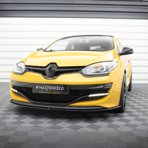 Yellow Renault car facing forward in a showroom, close-up of front with prominent Renault badge and black grille, '#MAXTONIZED' plate visible