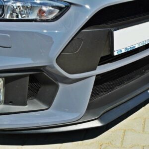 Close-up of a light-blue car front bumper showing a fog light, black mesh grille, and the license plate area.