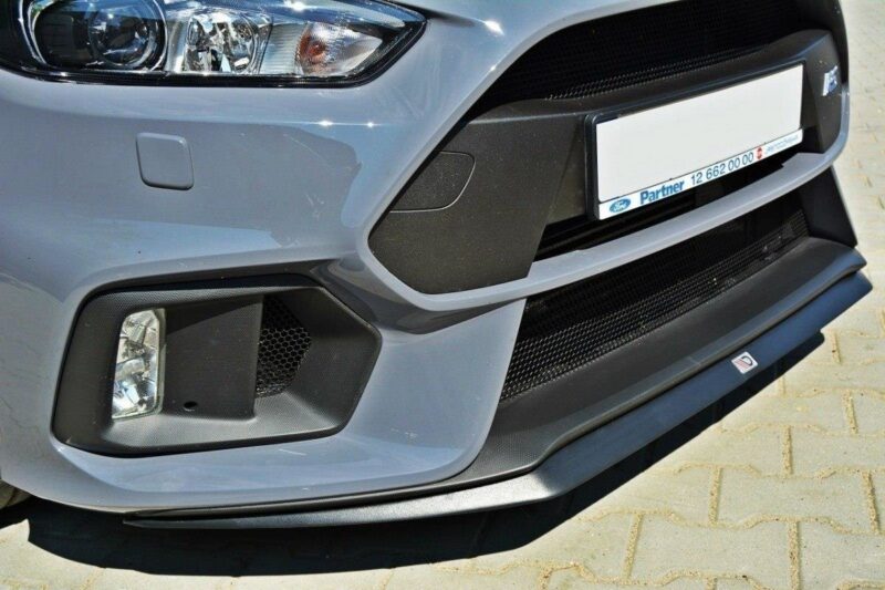Close-up of a light-blue car front bumper showing a fog light, black mesh grille, and the license plate area.