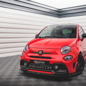 Front-right view of a bright red compact car (Abarth) parked indoors against white ribbed walls; glossy finish and black accents visible.