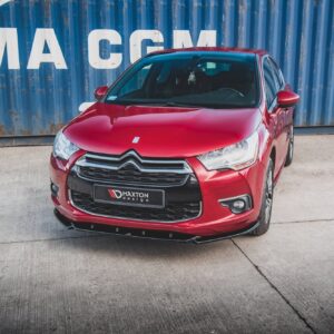 Red Citroën car parked in front of a blue shipping container with CMA CGM lettering.