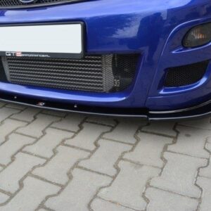 Front view of a blue sports car showing its aggressive lower bumper, mesh grille, and front lip splitter on a paved surface.