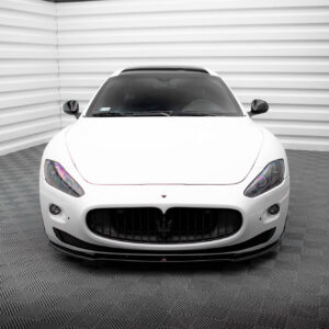 White Maserati front view in a minimalist studio with striped walls in the background.
