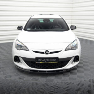 Front view of a white Opel car in a studio setting with a checkered gray floor and white corrugated walls behind it, showing daytime running lights and grille detail.