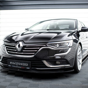 Close-up front three-quarter view of a glossy black Renault sedan in a bright showroom, emphasizing the grille and badge (#MAKTONIZED).