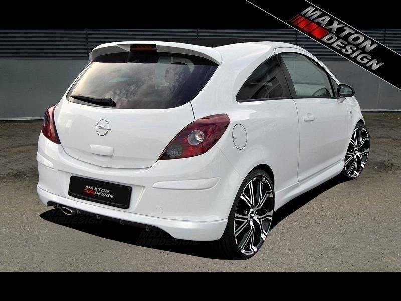 pol_po_REAR-BUMPER-EXTENSION-suitable-for-Opel-CORSA-D-543_1jpg - OPSHOLDERS White Opel hatchback parked outdoors, rear three-quarter view with black multi-spoke aftermarket wheels and Maxton Design branding.