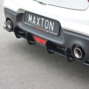 Rear view of a white sports car showing a Maxton license plate and carbon-fiber diffuser.