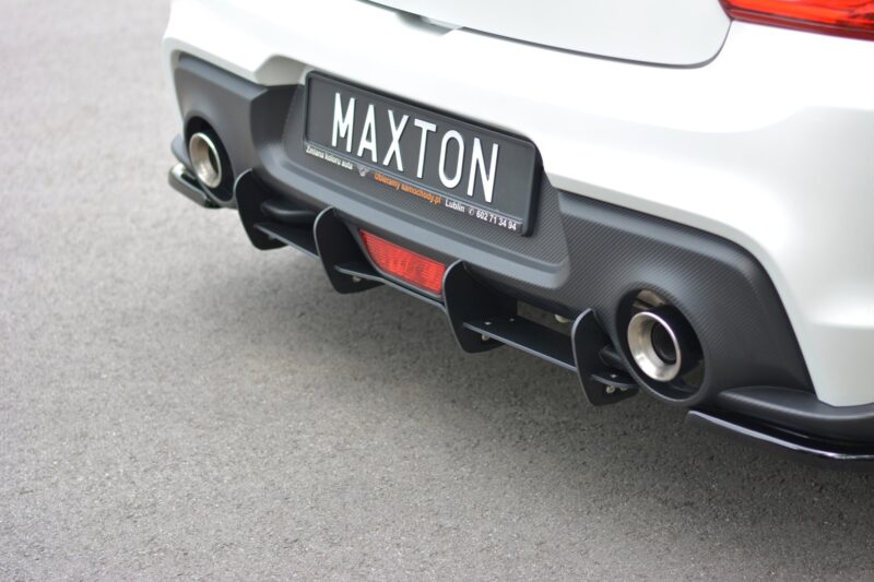 Rear view of a white sports car showing a Maxton license plate and carbon-fiber diffuser.