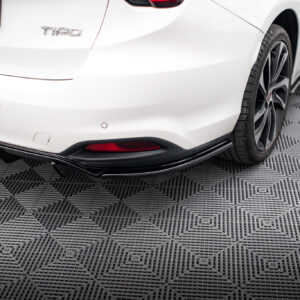 Rear of a white car showing the trunk with a 'T100' badge, red taillight, and curved bumper.