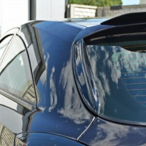 Close-up of a dark blue car showing the door and rear window with reflections of clouds in the glass, parked in a driveway.