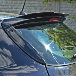 Rear window of a dark blue car showing a wiper blade and a small spoiler, with reflections of trees and sky in the glass.