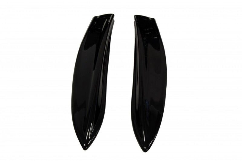 Pair of glossy black curved plastic pieces placed side by side, resembling sleek fins or shells.