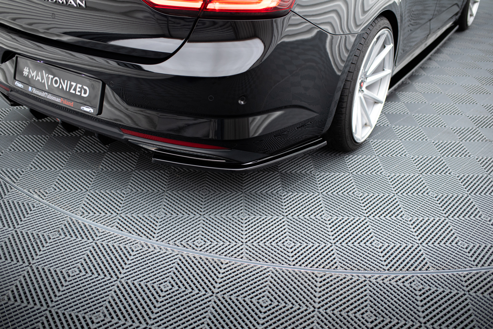 pol_po_Rear-Side-Splitters-suitable-for-Renault-Talisman-1143_3jpg - OPSHOLDERS Black luxury car rear with glossy finish and a bold license plate reading #MAXTONIZED, parked on a checkered showroom floor.