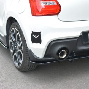 White car rear featuring a black pig sticker on the rear fender near the wheel and a bold rear bumper with a visible exhaust.