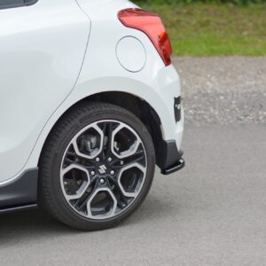 pol_po_Rear-Side-Splitters-suitable-for-Suzuki-Swift-Mk6-8260_2jpg - OPSHOLDERS White car rear quarter panel with red taillight, round fuel door, and alloy wheel over a paved surface