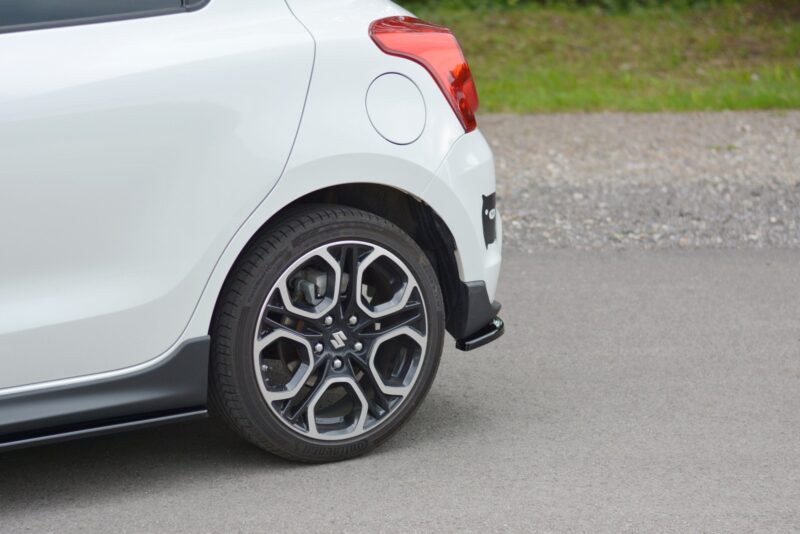 pol_po_Rear-Side-Splitters-suitable-for-Suzuki-Swift-Mk6-8260_2jpg - OPSHOLDERS White car rear quarter panel with red taillight, round fuel door, and alloy wheel over a paved surface