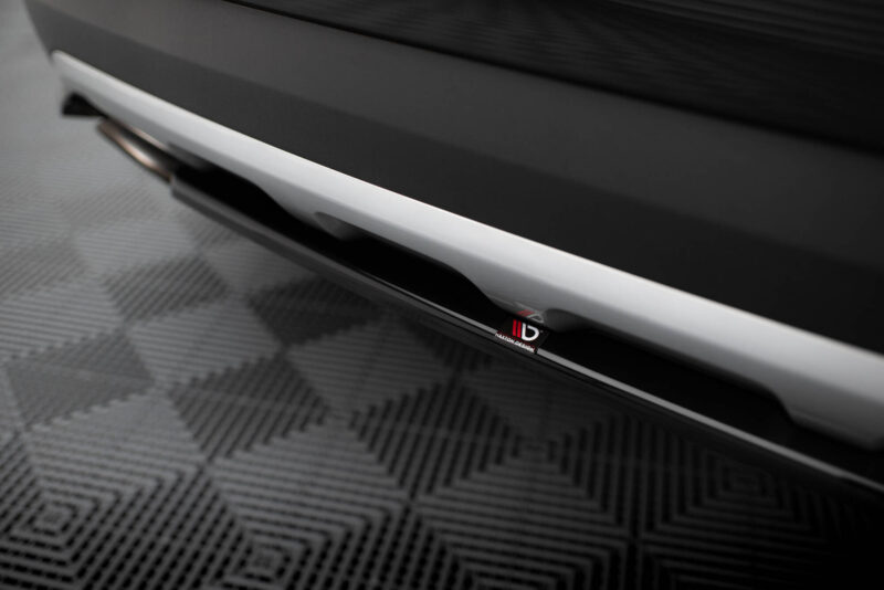 Close‑up of a car's side skirt with a white trim and a small Maxton Design badge visible under glossy black paint scope (car accessory).