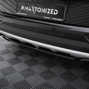 Rear view of a black Kia car showing a license plate that reads '#MAXTONIZED' with small text 'KIA MOTO' and 'Chorzów | moto.com.pl' on the plate.