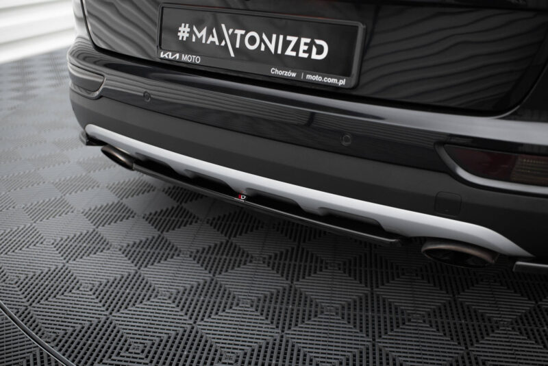 Rear view of a black Kia car showing a license plate that reads '#MAXTONIZED' with small text 'KIA MOTO' and 'Chorzów | moto.com.pl' on the plate.