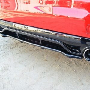Rear view of a red car showing dual exhausts and a glossy black diffuser on dirt ground.`,`The back of a red vehicle with two round exhaust outlets and a chrome-accented rear diffuser.`,`Close-up of a red car's rear bumper featuring twin exhaust pipes and a sleek black trim diffuser.`,`Rear bumper detail: red car, chrome trim, dual exhausts, on a dusty surface.`,`Back end of a red car with dual exhaust outlets and a stylish diffuser, reflected on the bumper.