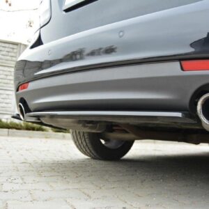 pol_po_Rear-Splitter-suitable-for-Saab-9-3-Aero-Mk2-Facelift-1054_5jpg - OPSHOLDERS Rear of a silver car showing a large circular exhaust tip on the right side of the bumper, parked on a brick-paved driveway beside a stone wall.
