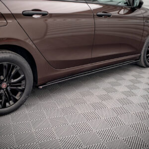 Brown car shown in side profile with two doors, door handles, and black alloy wheels on a patterned metal floor.