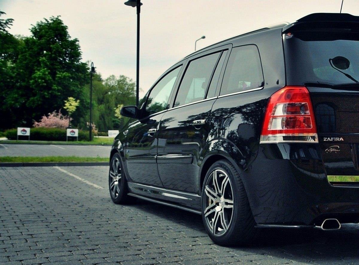 pol_po_SIDE-SKIRTS-DIFFUSERS-suitable-for-Opel-ZAFIRA-B-OPC-254_1jpg - OPSHOLDERS Black Vauxhall Zafira minivan parked in a paved lot, rear three-quarter view with alloy wheels and green trees in the background