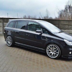pol_po_SIDE-SKIRTS-DIFFUSERS-suitable-for-Opel-ZAFIRA-B-OPC-254_4jpg - OPSHOLDERS Black minivan with large silver aftermarket alloy wheels parked on a brick driveway in front of a wooden fence.