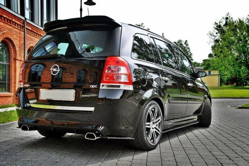 pol_po_SIDE-SKIRTS-DIFFUSERS-suitable-for-Opel-ZAFIRA-B-OPC-254_6jpg - OPSHOLDERS Black Opel Zafira OPC minivan parked on a brick-paved driveway with a brick building in the background.