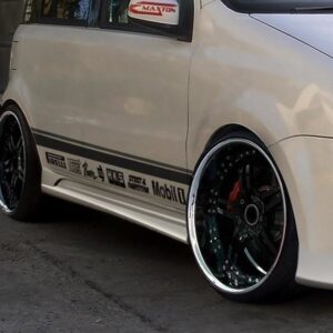 White modified car with oversized black wheels and racing decals along the side.