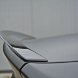 Close-up of a gray car's rear spoiler and trunk edge.